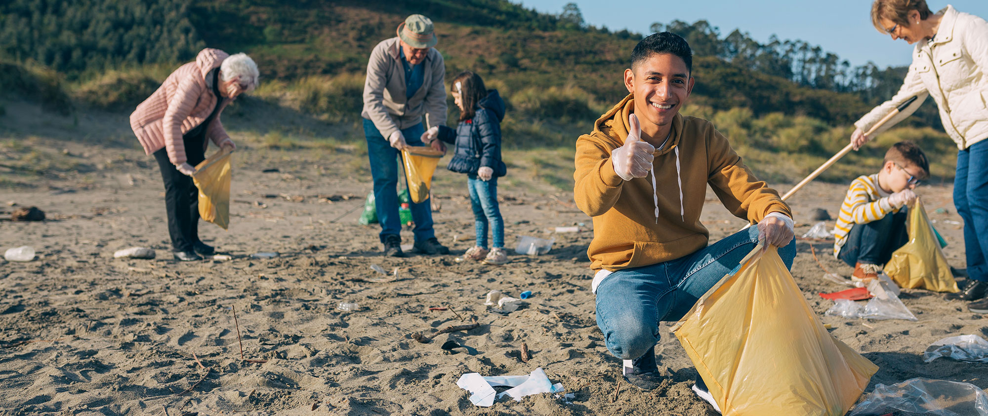 young person picking litter on the beach